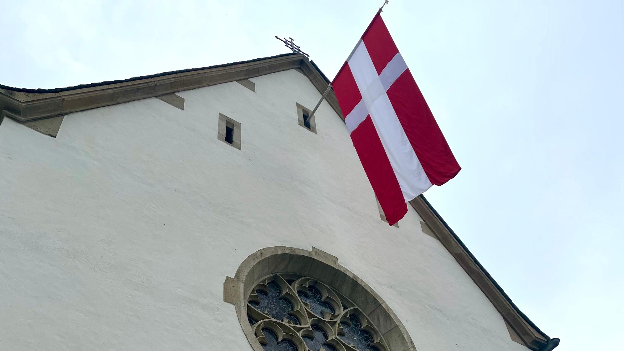 Blick von unten auf die hängende Fahne an der Kapelle