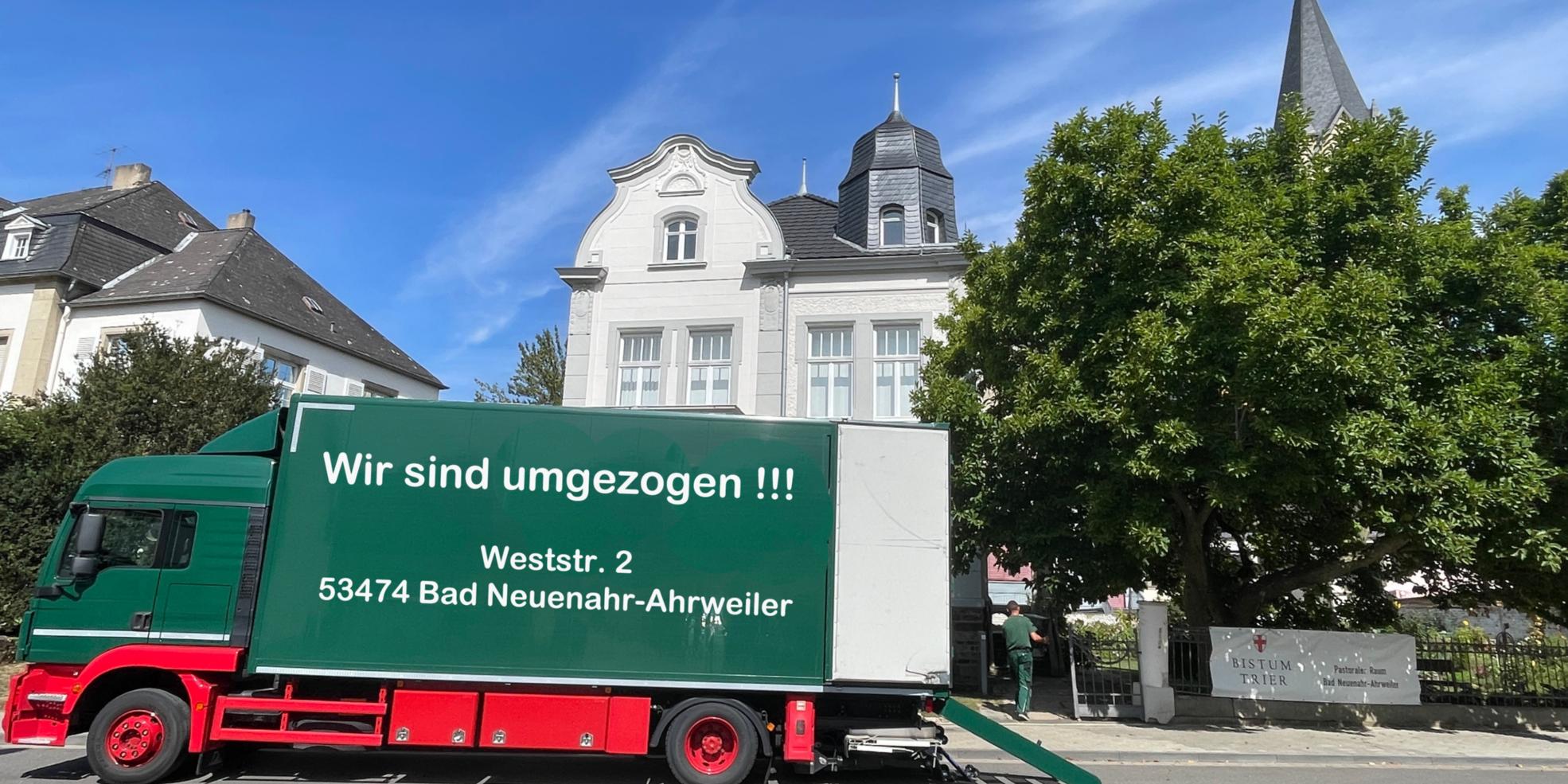 Gebäude Weststr. 2 mit grünem Umzugs-LKW und Aufschrift: 'Wir sind umgezogen'